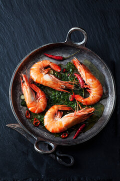 Prawns with hernbs, chili and garlic in iron pan