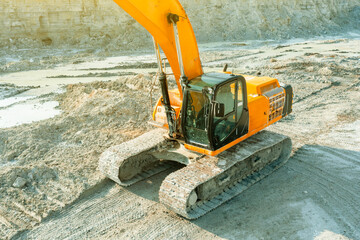 An excavator at a construction site plans the ground before work on the foundation