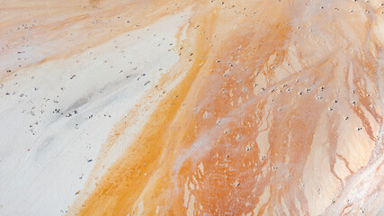 Beautiful orange texture on the ground, a view from a great height, an old flooded quarry. Rusty...