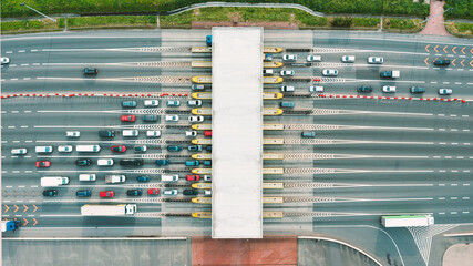An overhead view of a busy toll road with many cars queuing up to pay the highway toll