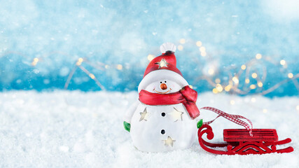 Happy snowman with red sleigh on snow. 
