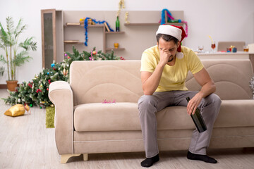 Young man cleaning the apartment after Christmas party