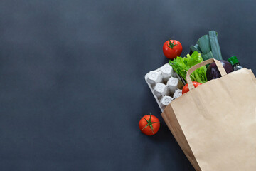 Paper bag full of food on black background. Food delivery concept