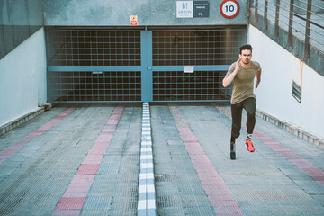 Disabled athlete with leg prosthesis running up ramp at a garage