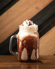 Sweet chocolate frappe with whipped cream served in long glass.