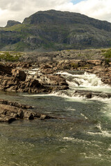 The waterfall in the national park Stora Sjöfallet in Sweden. This is made near the Storasjofallet Mountain lodge. Made in the summer time.