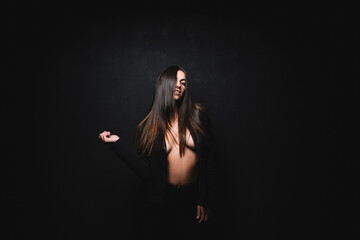 Portrait of sexy young woman in front of black background