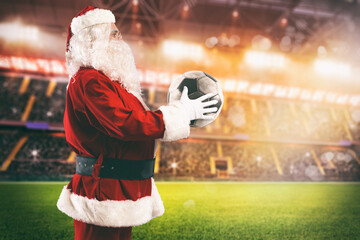 Santa Claus with a soccer ball in his hands inside a soccer stadium