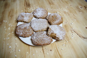 oat cookies on plate on wooden background, flat lay