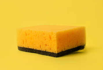yellow and black sponge for washing dishes on a yellow background