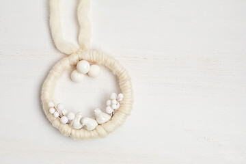 Christmas craft background with handmade yarn christmas wreath in white color. DIY organic sustainable christmas decoration