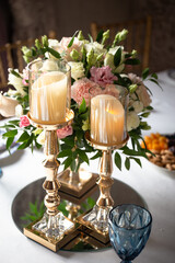 a glass candlestick next to the flowers. festive decoration