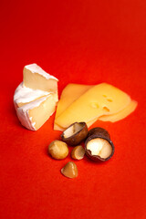 cheese and macadamia nuts on a red background