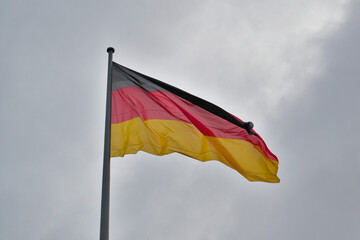 German flag against a grey cloudy sky