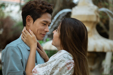 Closeup of romantic moment of asian european couple hugging and looking in each other eyes, attractive korean young man