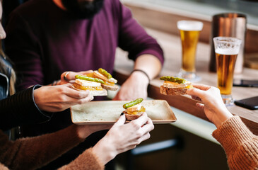 Friends in restaurant sharing starters, close up