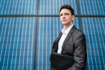 Businessman holding folder standing in front of solar panels