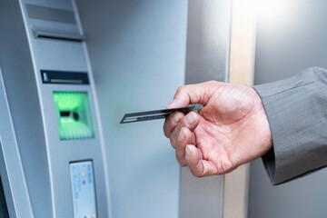 Close-up of businessman withdrawing money at an ATM