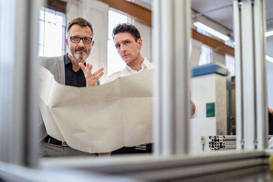 Two businessmen discussing plan in a factory
