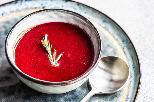 Bowl of creamy beetroot soup with fresh rosemary