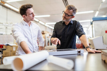 Two colleagues in factory working on solar cell