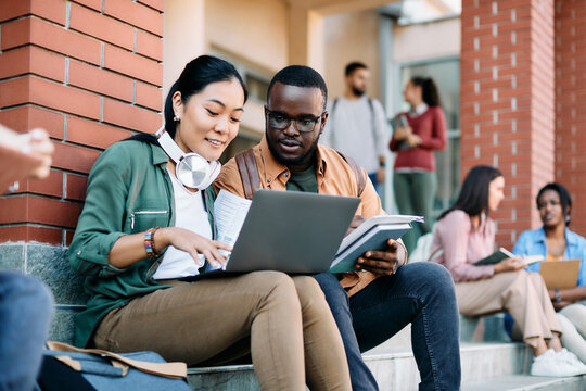 Young multiracial students use laptop while learning at campus. - Powered by Adobe