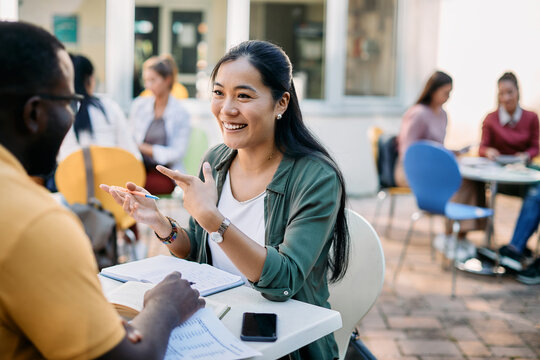 Young Happy Asian Woman Talks With Her College Friend While Studying Together At Campus.