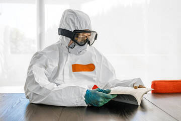 Woman, wearing protective clothes, sitting at table, reading book