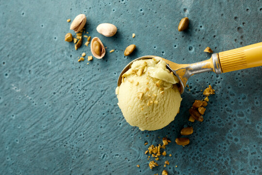 Pistachio ice cream on scoop and nuts