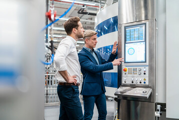 Two businessmen talking in a modern factory