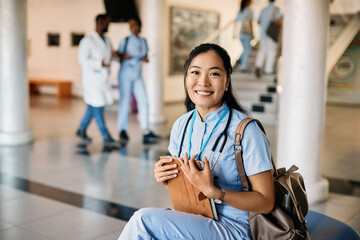 Happy Asian nursing student at medical university looking at camera.