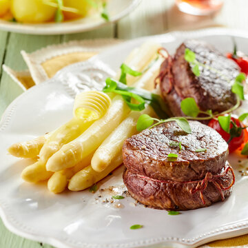 White asparagus and beef fillet on plate in restaurant