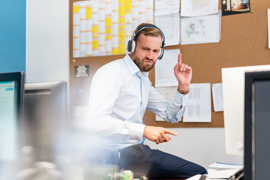 Businessman Listening To Music With Headphones In Office