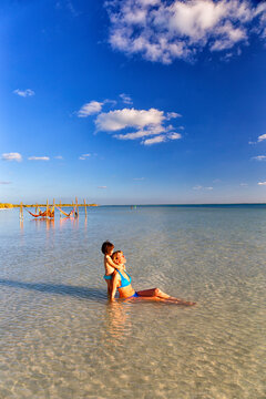 Mother and daughter sunbathing at beach in Holbox Island, Cancun, Mexico