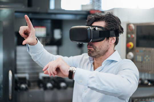 Businessman using VR glasses in a factory