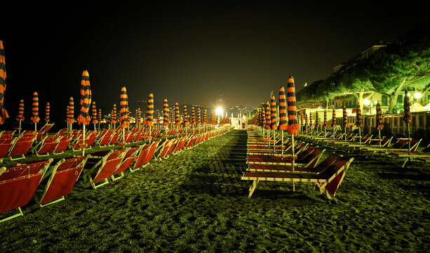 Beach with sun loungers at night, San Bartolomeo al Mare, Italy