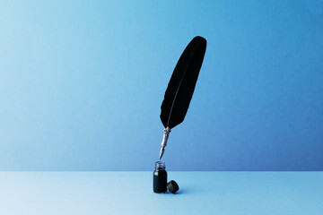 Quill pen and inkwell over blue background