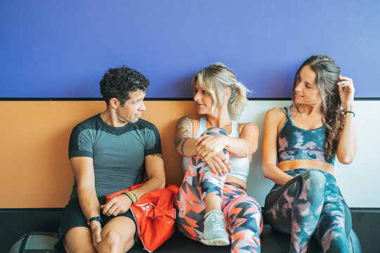 Three athletes having a break and talking in gym