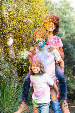 Family full of colorful powder paint, celebrating Holi, Festival of Colors