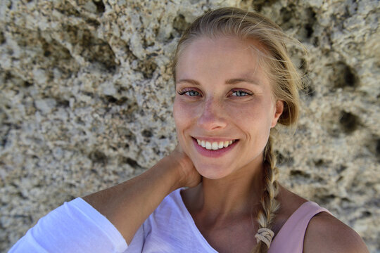 Portrait Of Smiling Blond Woman With Rocky Background