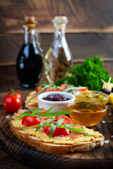 Grilled bruschetta with chicken rillettes, jamon and herbs. Delicious toast with chicken pate and different appetizers