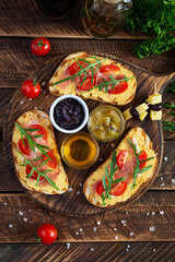 Grilled bruschetta with chicken rillettes, jamon and herbs. Delicious toast with chicken pate and different appetizers