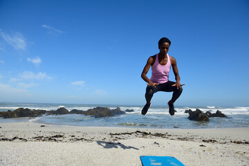 Sportive woman jumping on the beach