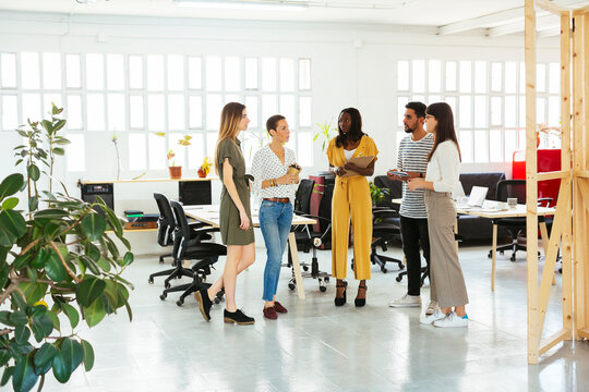 Colleagues standing and brainstorming in office