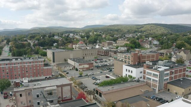 A slow forward aerial establishing shot of the downtown district of Altoona, Pennsylvania on an early Fall day.  	