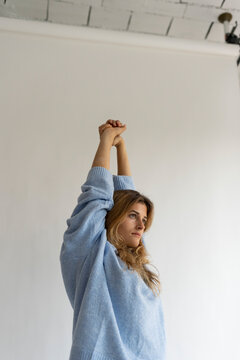 Young woman wearing pullover stretching