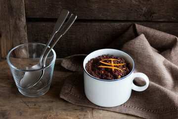 Mug of gluten and lactose free chocolate pudding with canihua, chili and orange