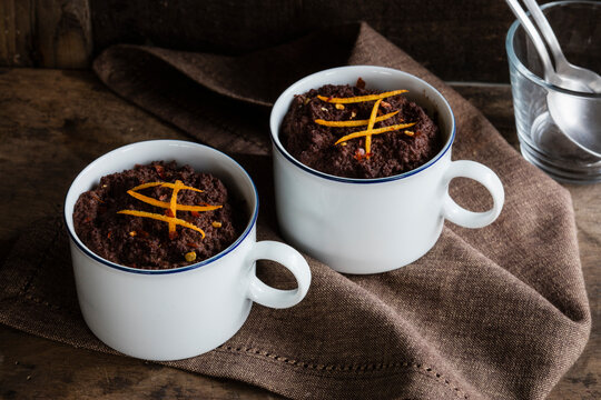 Mugs of gluten and lactose free chocolate puddings with canihua, chili and orange