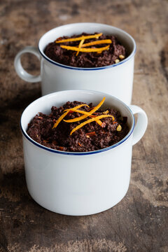 Mugs of gluten and lactose free chocolate puddings with canihua, chili and orange