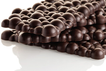 Black raw chocolate stack of bars on a white background. Isolate.